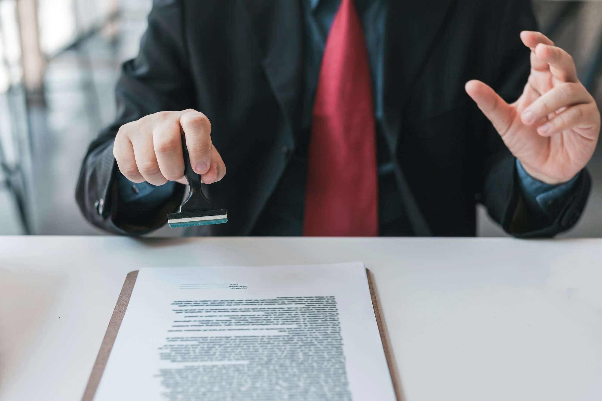 Businessman stamping with approved stamp on document contract.