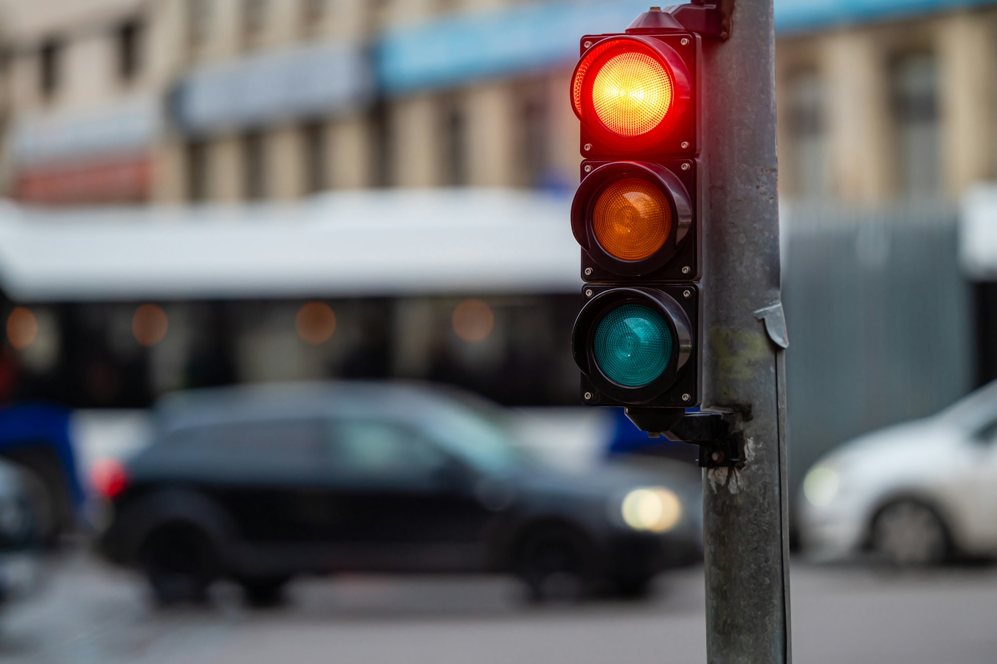 view of city traffic with traffic lights, in the foreground a traffic light with a red light